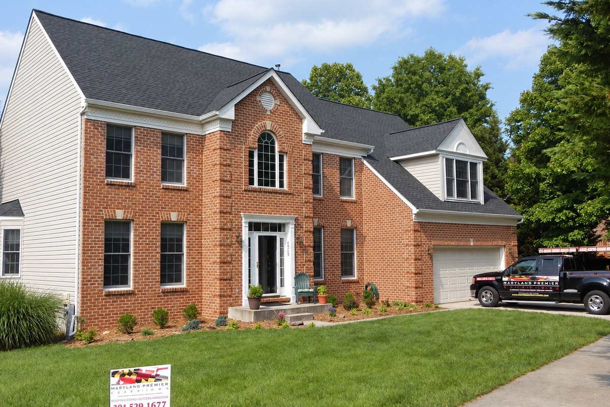 Finished red brick house with a new charcoal shingle roof and a black front door