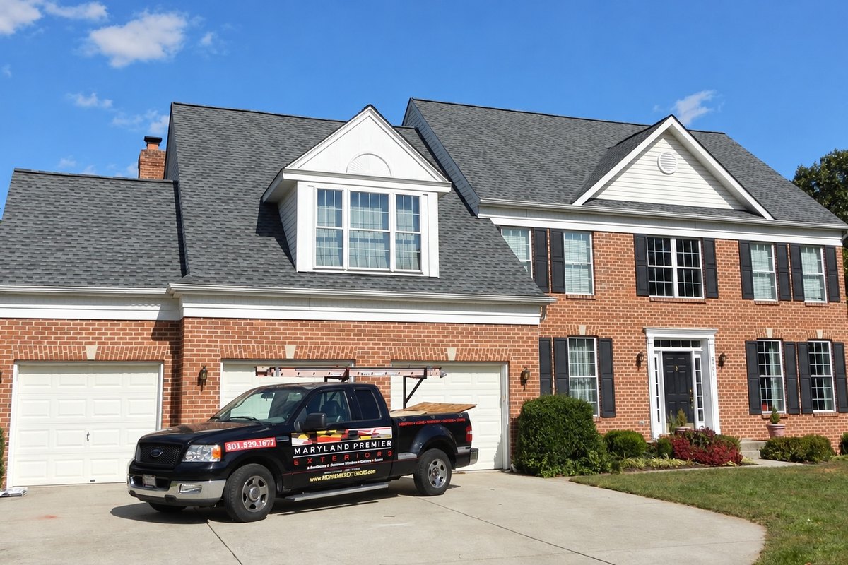 Finished brick colonial house with a new gray architectural shingle roof and black shutters