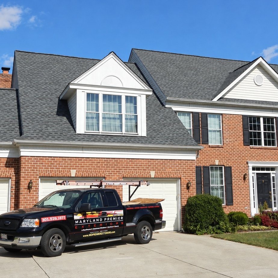 Finished brick colonial house with a new gray architectural shingle roof and black shutters