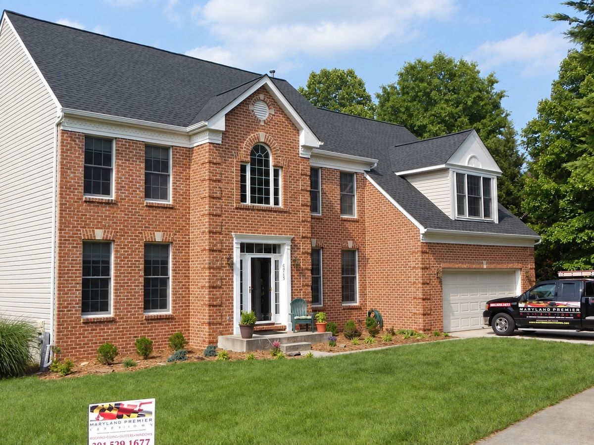 Finished two-story red brick house with white vinyl side wall and a new charcoal architectural shingle roof over a